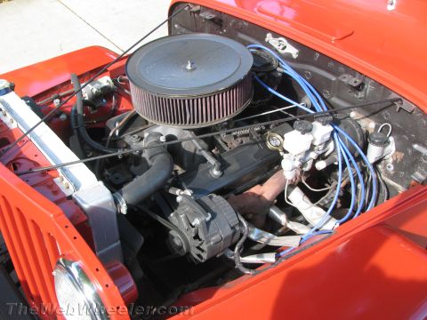 1968 Ford Mustang - The engine bay of a red Jeep is visible, an aftermarket air filter and updated components.