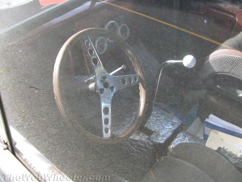 1968 Ford Mustang - Interior view of a car, focusing on the steering wheel, shifter, and dashboard gauges.