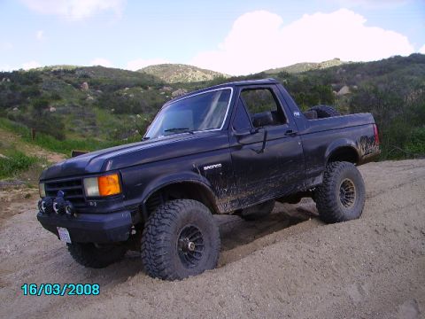 1990 Ford Bronco - This lifted 1990 Ford Bronco navigates a dusty, off-road trail.