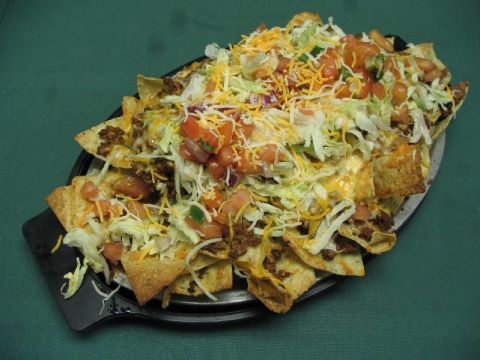 1985 Ford Bronco - A large platter of nachos topped with seasoned ground beef, shredded cheese, lettuce, and diced tomatoes.
