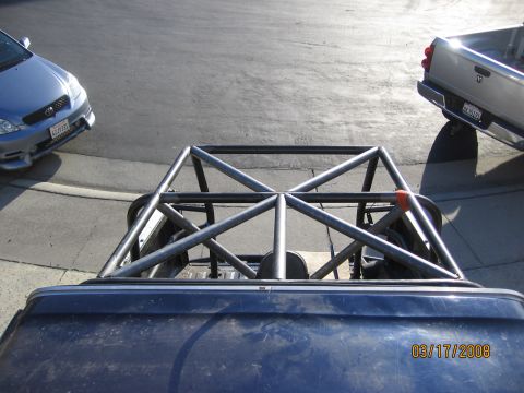 1994 Ford Bronco - A custom roll cage is installed in the bed of a pickup truck, with two other vehicles visible in the background.