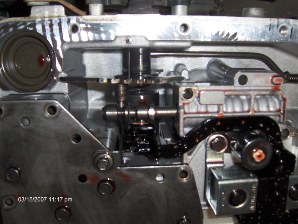 Close-up of a transmission valve body with visible fluid and mechanical components