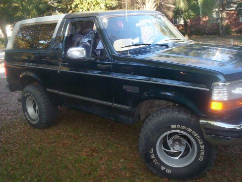 1995 Ford Bronco - This 1995 Ford Bronco is shown from a 3/4 front angle, its dark green paint and white removable top.