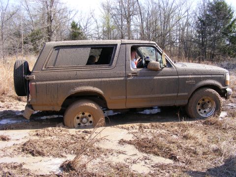 1981 Jeep CJ7 - This muddy Ford Bronco is stuck in a ditch during an off-road excursion.