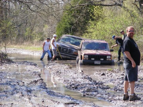 1981 Jeep CJ7 - Several people attempt to free two off-road vehicles that are stuck deep in the mud.