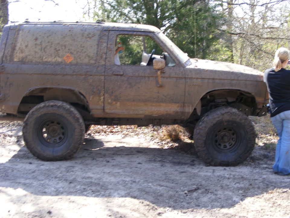 Mud-covered 1983 Ford Bronco II side view, lifted with large tires