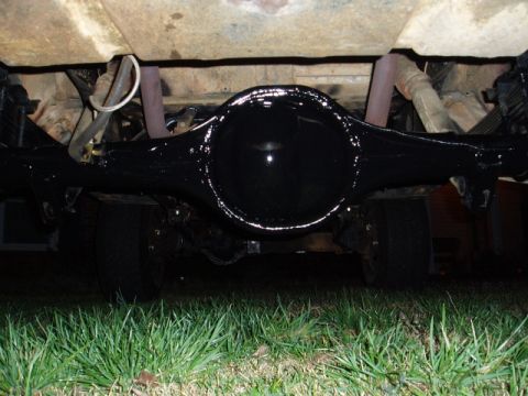 1980 Ford Bronco - The underside of a vehicle shows a freshly painted black rear differential and suspension system.