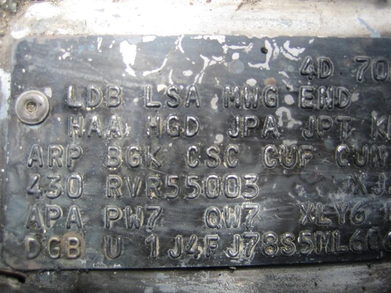 Weathered embossed option code plate with three-letter codes and partial serial numbers