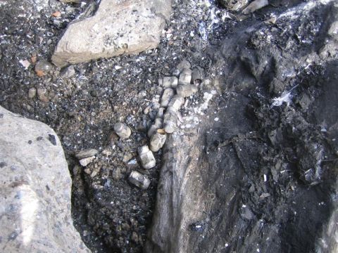 1987 Suzuki Samurai - Lug nuts are visible amidst the debris and ash of a burnt area.