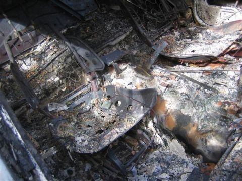1987 Suzuki Samurai - The interior of a vehicle shows extensive fire damage to the seats and floor.