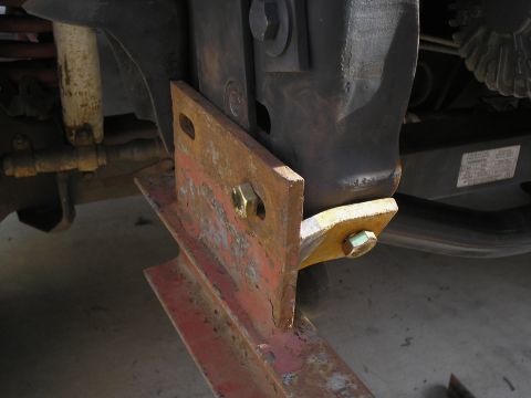 1990 Ford Bronco - A close-up view of a rusty tow hitch bracket mounted to a vehicle's frame.