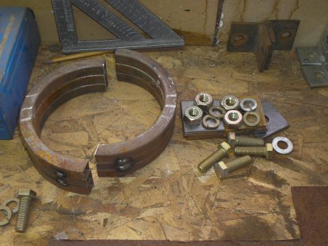 1999 Ford F-800 - Metal driveshaft hoops and hardware are laid out on a workbench, ready for assembly.