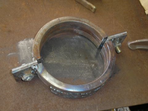 1999 Ford F-800 - A custom metal clamp, possibly for automotive use, is shown on a workbench.