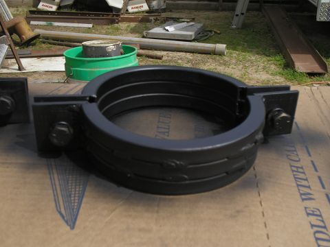 1999 Ford F-800 - A black driveshaft hoop part is shown resting on cardboard, with other items in the background.