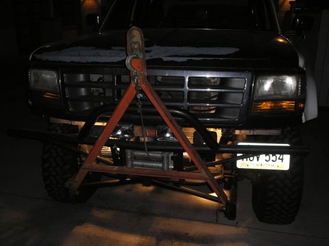 1990 Ford Bronco - This truck features a custom bumper and tow rig, obscuring the grille and headlights.