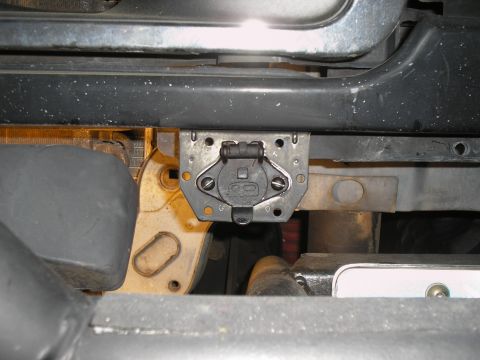 1990 Ford Bronco - Close-up view of a trailer hitch connector, showing its mounting bracket and electrical connections.