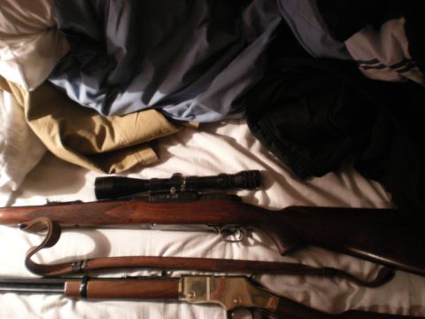 1993 Ford Bronco - Two rifles are visible on a bed, one equipped with a scope.