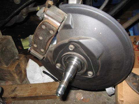 1968 Shelby GT500 - Close-up view of a vehicle's front brake assembly, including the drum, caliper, and spindle.