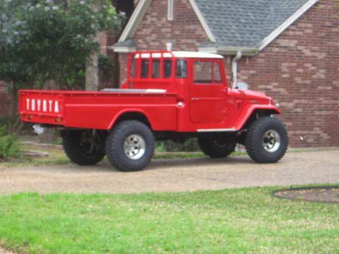 1986 Ford Bronco - This red Toyota Land Cruiser FJ45 pickup truck has a white roof and off-road tires.