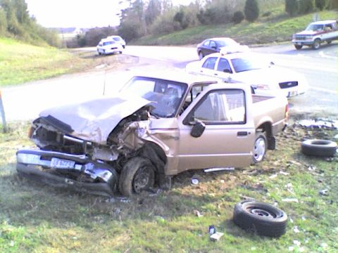 1990 Ford Bronco - This pickup truck sustained heavy damage in an accident. Other vehicles are present in the background.