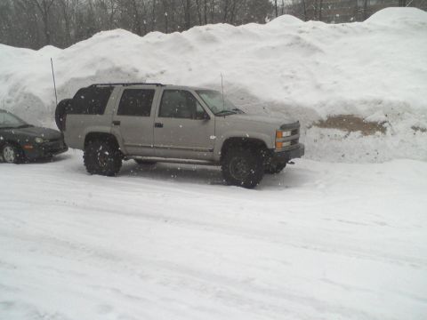 2000 Chevrolet Tahoe - Silver SUV parked in a snowy area with a large snowdrift behind it.