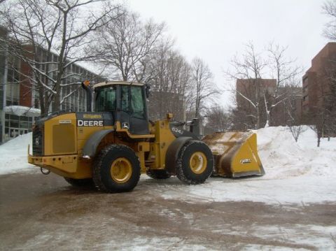 2000 Chevrolet Tahoe - John Deere 624J wheel loader is seen clearing snow in a winter setting.