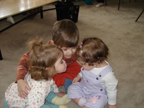 2000 Ford Crown Victoria - Three children gathered together on the floor, sharing a moment.