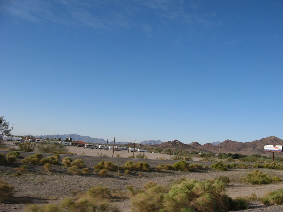 RV park scene with mountains and a billboard