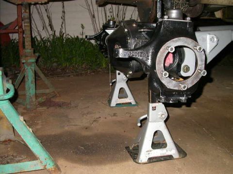 1990 Ford Bronco - Vehicle's rear axle assembly is raised and supported by jack stands for maintenance.