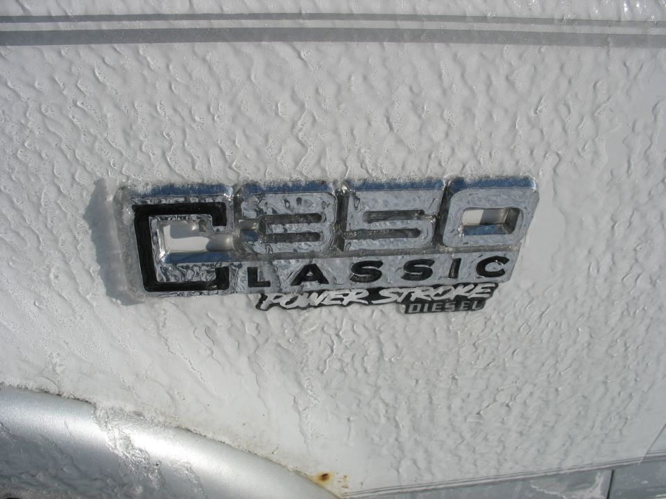Close-up of a C350 Classic Power Stroke Diesel emblem on a white vehicle