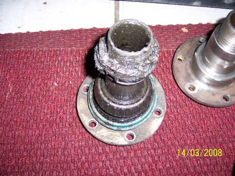 1991 Ford Bronco - A severely damaged wheel bearing assembly, likely from a seized bearing, is shown with visible grease and metal fragments.