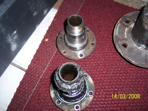 1991 Ford Bronco - Two used wheel bearings are shown on a red carpet, one appears to be heavily greased and dirty.