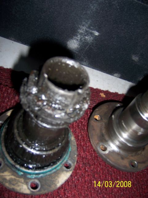 1991 Ford Bronco - Close-up of a severely damaged wheel bearing assembly, showing signs of wear and contamination.