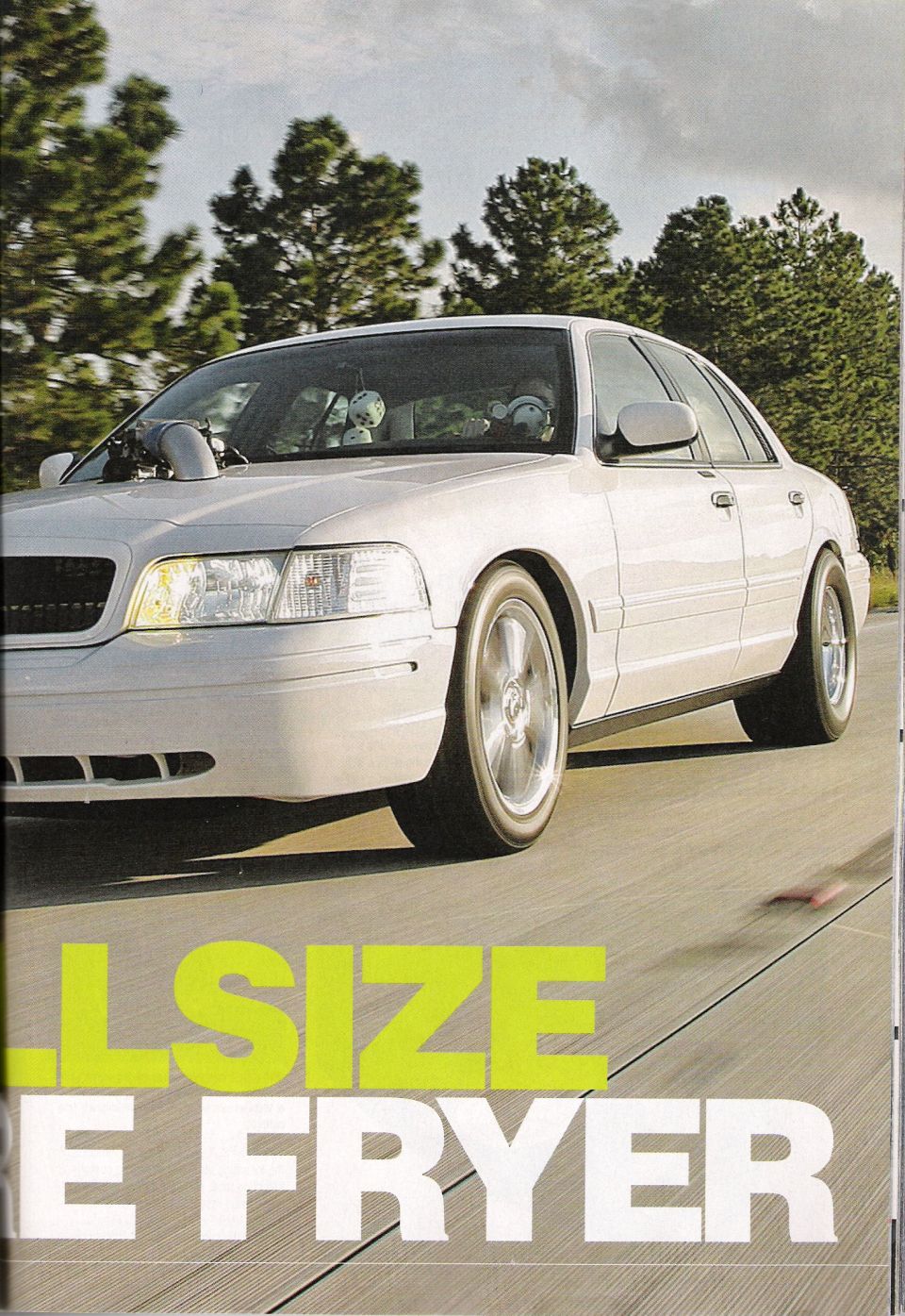 Magazine photo of a white four-door sedan on a track, 'FULLSIZE FRYER'