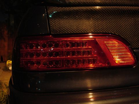 1993 Ford Taurus - Close-up of a vehicle's rear tail light an LED array and a carbon fiber trunk lid.