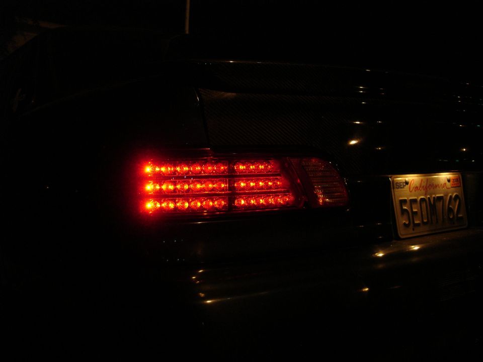 close-up of car's rear with red LED tail lights illuminated and a California license plate reading 5EOM762