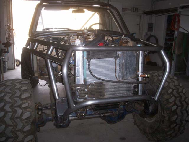 Front view of a custom off-road vehicle with a prominent roll cage and large tires
