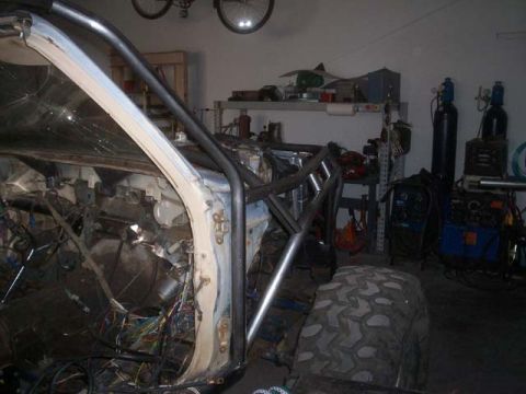 1982 Toyota 4Runner - A vehicle interior undergoing modifications, a custom roll cage and extensive wiring.