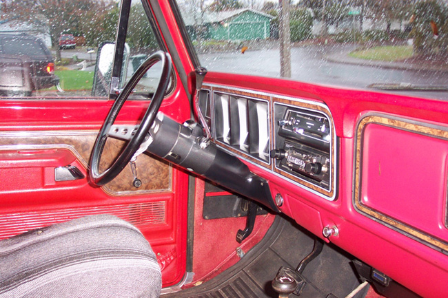 1978 Ford Bronco interior showing dashboard, steering wheel, and passenger seat with blanket