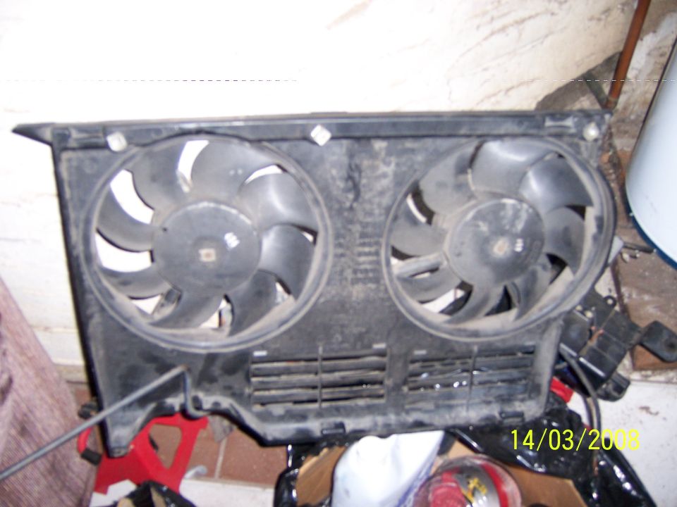 Dual electric cooling fans mounted in a black plastic shroud with horizontal vents