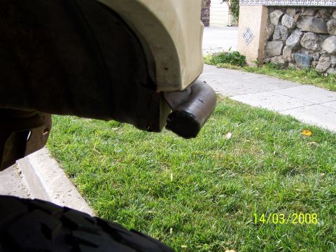 1991 Ford Bronco - Close-up of a damaged vehicle bumper, showing a dark pipe protruding from the corner.