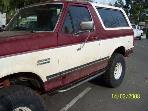 1991 Ford Bronco - This 1991 Ford Bronco features a two-tone paint scheme and aftermarket rock sliders, seen here in a side profile.