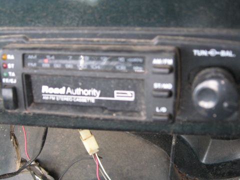1988 Ford Bronco - Close-up of an aftermarket car stereo with a cassette player and visible wiring.