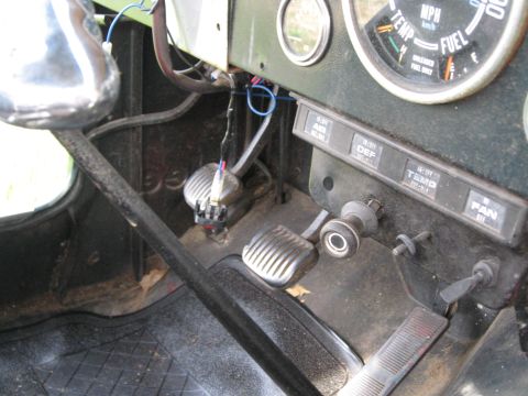 1988 Ford Bronco - The interior of a Jeep CJ displays its pedals, dashboard, and various control switches.