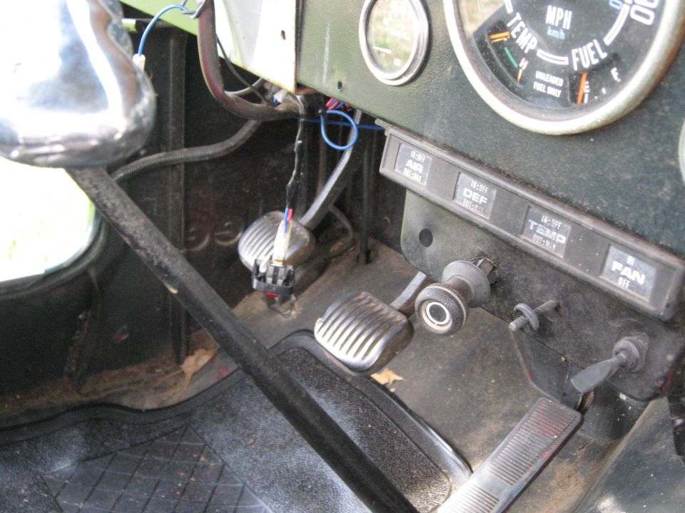 Jeep CJ interior showing pedals, dashboard gauges, and climate controls