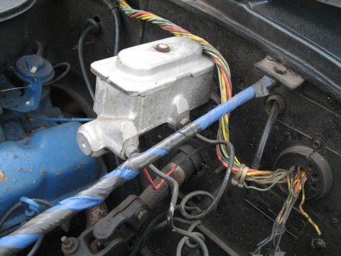 1988 Ford Bronco - Close-up view of the brake master cylinder and wiring harness in an engine bay.