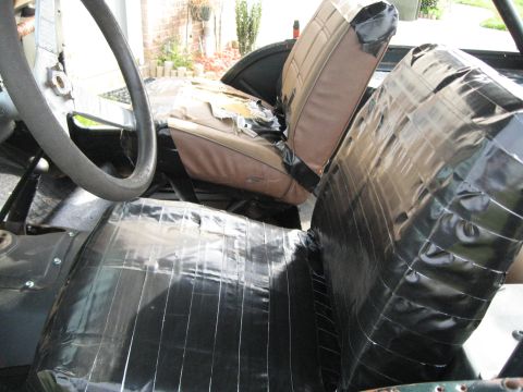 1988 Ford Bronco - The interior of a vehicle shows torn seats and extensive use of black tape for repairs.