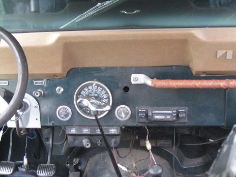 1988 Ford Bronco - The interior dashboard of a Jeep CJ shows the speedometer, auxiliary gauges, and radio.