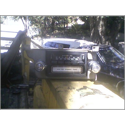 1973 Ford Ranchero - An old car radio with a tape deck is shown in a close-up view.