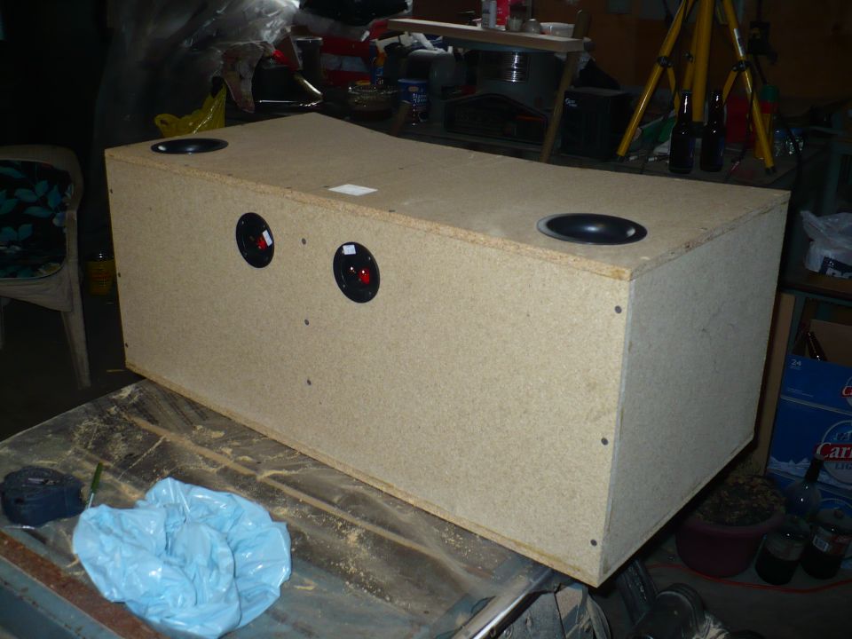 Wooden speaker box with two round speaker cutouts on the side and two on the top